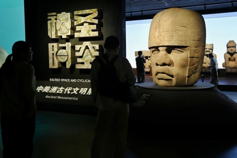 展厅内奥尔梅克巨石头像实景，观众参观